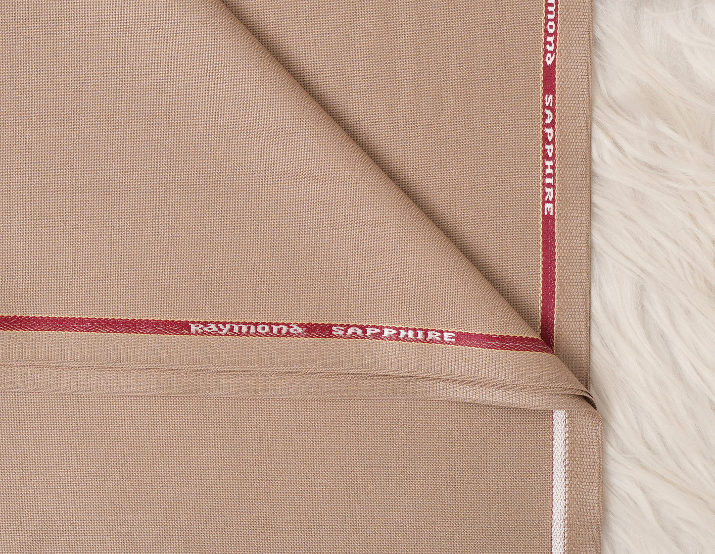 Close-up of beige fabric with 'Raymond Sapphire' branding.